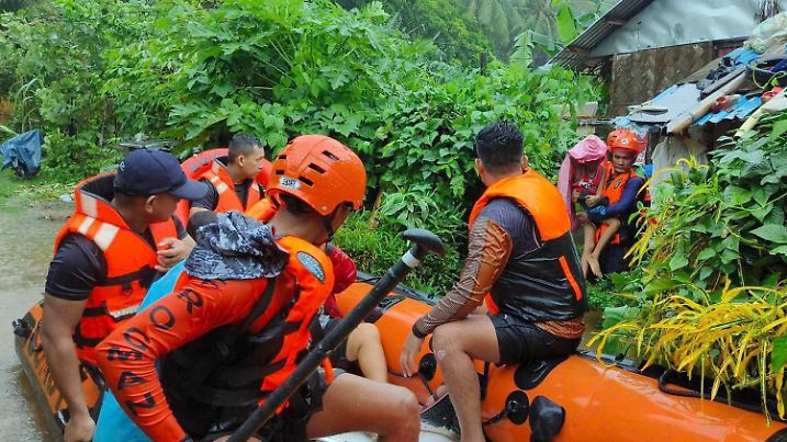 HANDOUT - 01.09.2024, Philippinen, Allen: Auf diesem von der philippinischen Küstenwache zur Verfügung gestellten Foto verwenden Rettungskräfte ein Gummiboot, während sie Bewohner nach Überschwemmungen aufgrund eines tropischen Sturms in höher gelegene Gebiete evakuieren. Foto: Uncredited/Philippine Coast Guard/AP/dpa +++ dpa-Bildfunk +++