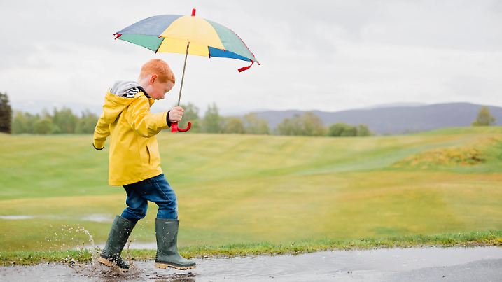Creative Highlights Symbolfotos Redheaded little boy with umbrella playing in the rain model released Symbolfoto NMS00298