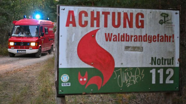 28.08.2024, Brandenburg, Rietzneuendorf-Staakow: Ein Einsatzfahrzeug der Freiwilligen Feuerwehr vom Amt Unterspreewald kommt aus einem Wald gefahren. Ein Feuer im Wald in der Nähe des «Tropical Islands» ist gelöscht. Die Ursache des Brandes bleibt unklar, Ermittlungen laufen. Der Waldbrand hatte am Nachmittag einen Großeinsatz der Feuerwehr ausgelöst. Foto: Patrick Pleul/dpa +++ dpa-Bildfunk +++