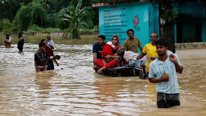 FILE PHOTO: People move a cart with a woman and child through a flooded street, in the Fazilpur area of Feni, Bangladesh, August 26, 2024. REUTERS/Mohammad Ponir Hossain/File Photo