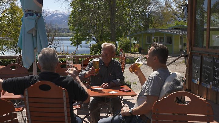 Menschen genießen ein Getränk im Biergarten.