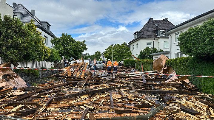 29.05.2024, Nordrhein-Westfalen, Hagen: Trümmer eines Kirchturmdaches liegen auf der Straße. Ein heftiger Starkwind hat am Mittwochnachmittag in Hagen zahlreiche Dächer beschädigt und Bäume umgeweht. (zu dpa «Starkwind deckt in Hagen Kirchendach ab und weht Bäume um») Foto: Alex Talash/dpa - ACHTUNG: Person(en) wurde(n) aus rechtlichen Gründen gepixelt +++ dpa-Bildfunk +++