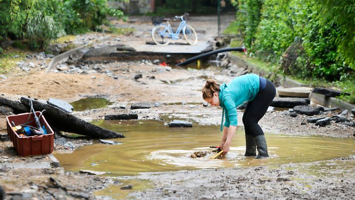03.06.2024, Tschechien, Plzeò: Eine Frau steht in der Ortschaft Tìnovice auf einer Straße, die durch eine Überschwemmung zerstört worden ist. Foto: Chaloupka Miroslav/CTK/dpa +++ dpa-Bildfunk +++