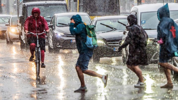 Wolkenbruch in Mitte, Menschen flüchten vor dem Starkregen, Verkehr im Unwetter, Berlin, 30. Mai 2024 Deutschland, Berlin, 30. Mai 2024, Menschen in Regencapes flüchten sich Richtung Bahnhof Alexanderplatz, Starkregen an der Karl-Liebknecht-Straße und am Alexanderplatz, nachmittags um 17 Uhr, Radfahrer, Autofahrer und Straßenbahn kämpfen sich durch die Regenmassen, der Wolkenbruch dauert eine halbe Stunde, Unwetter, Regen, *** Cloudburst in Mitte, people flee from the heavy rain, traffic in the storm, Berlin, May 30, 2024 Germany, Berlin, May 30, 2024, people in rain capes flee towards Alexanderplatz station, heavy rain on Karl Liebknecht Straße and Alexanderplatz, afternoon at 5 p.m., cyclists, motorists and streetcars fight their wa
