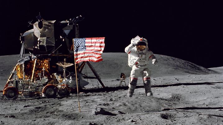 John W. Youngs Lunar Salute Astronaut John W. Young, commander of the Apollo 16 lunar landing mission, leaps from the Moon s surface as he salutes the United States flag at the Descartes landing site during the first Apollo 16 spacewalk. Astronaut Charles M. Duke Jr., lunar module pilot, took this picture on April 21, 1972. The Lunar Module Orion is on the left and beside it is the Lunar Roving Vehicle. Behind Young, in the shadow of Orion, is the Far Ultraviolet Camera/Spectrograph. Young and Duke conducted three surface excursions totaling more than 20 hours, using the Lunar Roving Vehicle for transportation. They deployed an experiment package, collected 209 pounds of rock and soil samples, and set up the first telescope on the Moon. M Copyright: xx as16-113-18339 CharlesxM.xDukexJr.x-xNASAxviaxCNPx cnpphotos261310