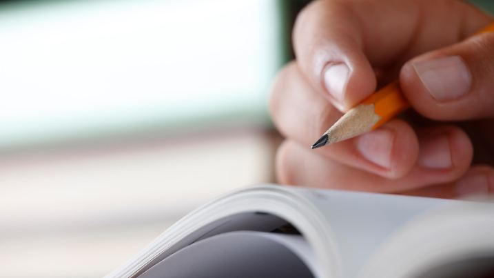 Kind hält Bleistift für Erstklässler.
