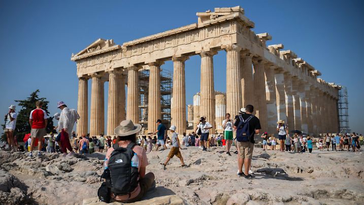 ARCHIV - 14.07.2023, Griechenland, Athen: Touristen gehen an einem heißen Tag bei ihrem Besuch des Parthenon-Tempels auf dem Akropolis-Hügel. (zu dpa: «Wegen Hitze: Akropolis mittags geschlossen») Foto: Angelos Tzortzinis/dpa +++ dpa-Bildfunk +++