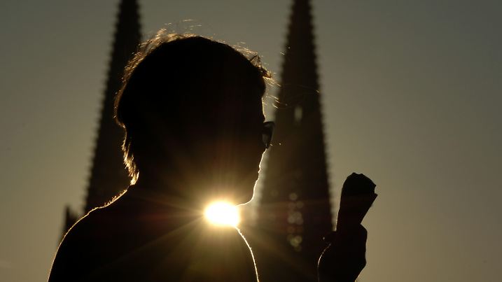 In der untergehenden Abendsonne genießt eine Frau am Donnerstag (22.09.2005) vor der Kulisse des Kölner Doms ein Eis. Der Herbst legt am Freitag (23.09.2005) einen freundlichen Start hin. Nach der Auflösung von Dunst und Nebel am Vormittag steht Nordrhein-Westfalen ein recht sonniger und warmer Tag ins Haus. Ein paar hohe Wolken können mit dem Sonnenschein vorerst kaum konkurrieren. Erst am späteren Nachmittag ziehen von Westen her Wolkenfelder auf. Es weht schwacher Wind aus südlichen Richtungen, und mit 20 bis 24 Grad Celsius wird es recht warm. Foto: Oliver Berg dpa/lnw +++(c) dpa - Bildfunk+++