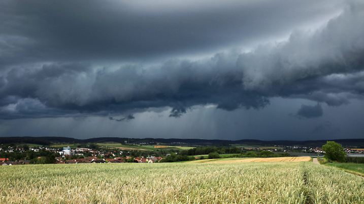 21.06.2024, Baden-Württemberg, Heilbronn: Eine Gewitterzelle mit dunklen Wolken baut sich am Himmel und hinter Feldern nahe Heilbronn auf. Der Deutsche Wetterdienst (DWD) hat gewarnt, es könne am Wochenende zu Gewittern und Starkregen kommen. Foto: Alexander Wolf/onw-images/dpa +++ dpa-Bildfunk +++