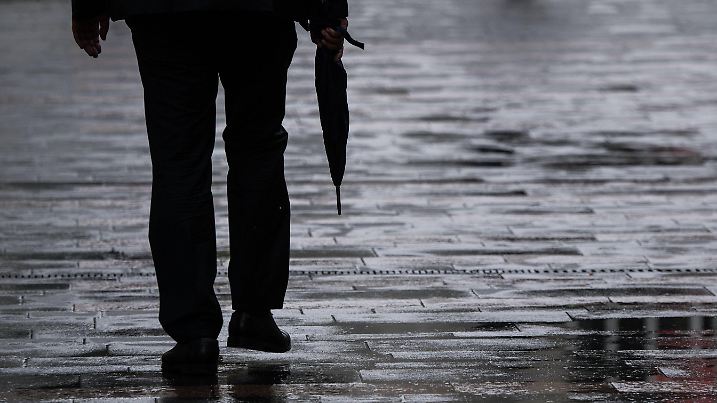 ARCHIV - 13.08.2018, Rheinland-Pfalz, Mainz: Ein Passant geht mit einem Regenschirm in der Hand durch eine Fußgängerzone. (zu dpa: «Regen und Gewitter in NRW - aber weiter hohe Temperaturen») Foto: Andreas Arnold/dpa +++ dpa-Bildfunk +++