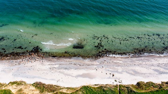 ARCHIV - 09.05.2023, Schleswig-Holstein, Strande: Wellen laufen am Strand der Ostsee am sogenannten Schwedeneck auf den Sand. (zu dpa: «Pilotbergung von Munitionsaltlasten in der Ostsee beginnt») Foto: Axel Heimken/dpa +++ dpa-Bildfunk +++
