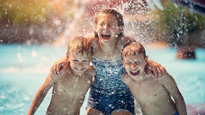 Kids having fun in pool in a waterpark. Laughing and screaming after being splashed with bucket of cold water.
Nikon D850