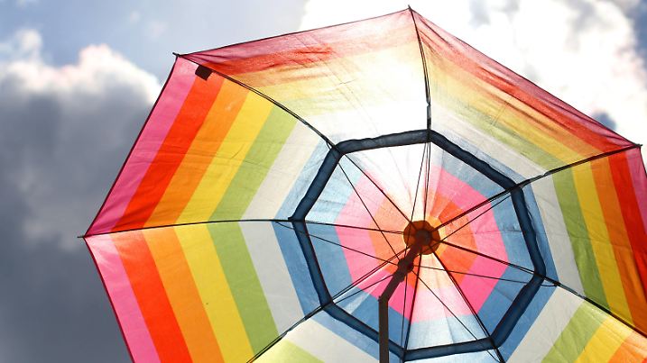 Feature Sommerwetter: Großer Sonnenschirm in Regenbogenfarben. *** Feature summer weather Large parasol in rainbow colors