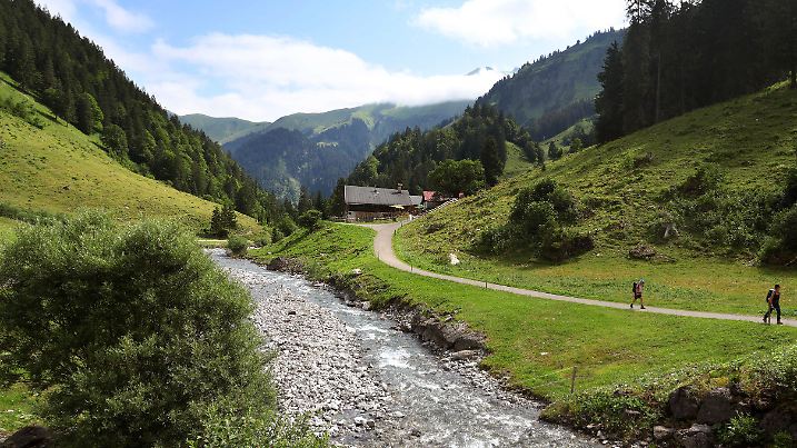 ARCHIV - 16.07.2023, Bayern, Oberstdorf: Ausflügler wandern im Rappenalptal entlang des Rappenalpbaches unter teilweise bewölktem Himmel. (zu dpa: «Gericht verhandelt über Zerstörung von Wildbach im Allgäu») Foto: Karl-Josef Hildenbrand/dpa +++ dpa-Bildfunk +++