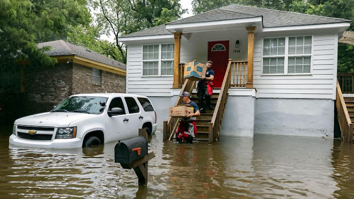 Savannah Fire Advanced Firefighters Ron Strauss, top, and Andrew Stevenson, below, carry food to residents in the Tremont Park neighborhood that where stranded in stormwater from Tropical Storm Debby, Tuesday, Aug. 6, 2024, in Savannah, Ga. (AP Photo/Stephen B. Morton)