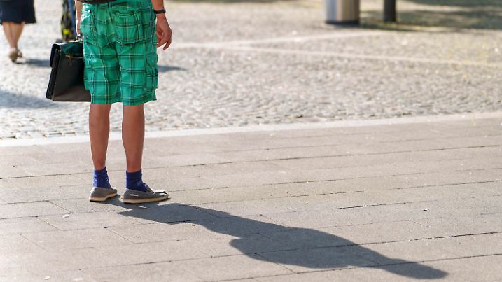 ARCHIV - 04.08.2022, Rheinland-Pfalz, Mainz: Ein Mann steht in kurzen Hosen in der Innenstadt. (Archivbild) (zu dpa: «Was Kommunen in Rheinland-Pfalz gegen Hitze und Versiegelung tun») Foto: Andreas Arnold/dpa +++ dpa-Bildfunk +++