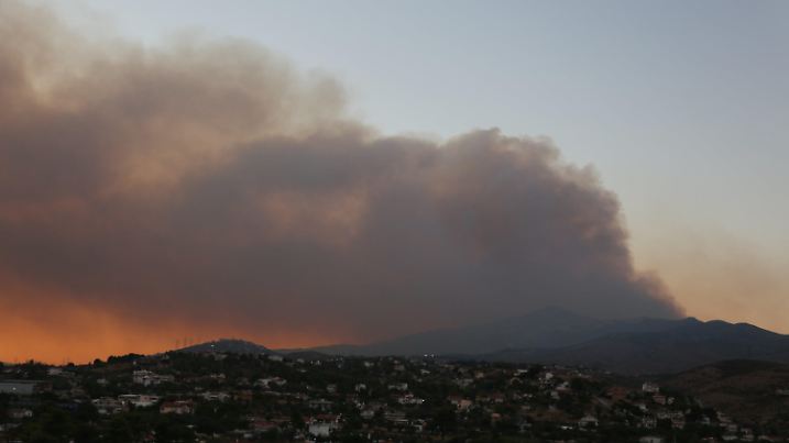 11.08.2024, Griechenland, Athen: Dunkler Rauch steigt auf über einem großen Waldbrand in Varnavas, etwa 35 km von Athen entfernt. Griechische Feuerwehrleute kämpften am Sonntag in der Nähe von Athen mehrere Stunden lang gegen einen großen Waldbrand, der die Evakuierung von fünf Siedlungen erzwungen hat, wie die Feuerwehr mitteilte. Fünf Bewohner unter den Evakuierten wurden mit leichten Verletzungen in Krankenhäuser gebracht, die meisten mit Atemproblemen aufgrund einer Rauchvergiftung, sagte Gesundheitsminister Adonis Georgiadis. Das Feuer brach gegen 15.00 Uhr Ortszeit in Varnavas, etwa 35 km von Athen entfernt, in der nordöstlichen Region Attika in der Nähe von Marathon aus. Foto: Chen Gang/XinHua/dpa +++ dpa-Bildfunk +++