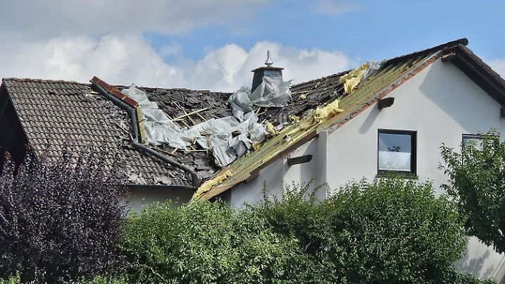HANDOUT - 25.08.2024, Nordrhein-Westfalen, Attendorn: Das Dach eines Wohnhauses ist nach einem Unwetter zerstört. Ein heftiges Unwetter hat in Attendorn massive Schäden angerichtet. Foto: Feuerwehr Attendorn/dpa - ACHTUNG: Nur zur redaktionellen Verwendung im Zusammenhang mit der aktuellen Berichterstattung und nur mit vollständiger Nennung des vorstehenden Credits +++ dpa-Bildfunk +++