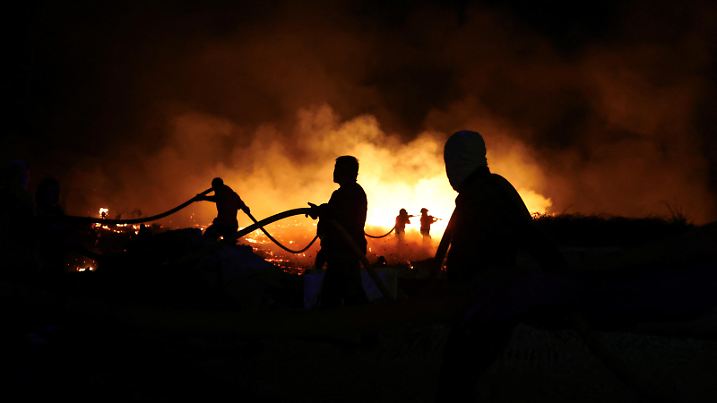 Firefighters try to extinguish a wildfire in Canas de Senhorim, Portugal, September 16, 2024. REUTERS/Pedro Nunes