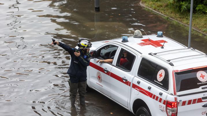 ARCHIV - 05.09.2024, Italien, Mailand: Einsatzkräfte sprechen am Ort einer überschwemmten Straße, nach einem Unwetter. (zu dpa: «Feuerwehrmann in Italien bei Unwetter getötet») Foto: Stefano Porta/LaPresse via ZUMA Press/dpa +++ dpa-Bildfunk +++