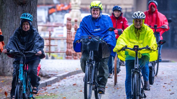 24.09.2024, Mecklenburg-Vorpommern, Schwerin: Fahrradfahrer sind bei Regen im Schlossgarten unterwegs. Mit Regen und Temperaturen um die 12 Grad zeigt sich das Herbstwetter in Norddeutschland von seiner unfreundlichen Seite. Foto: Jens Büttner/dpa - ACHTUNG: Nur zur redaktionellen Verwendung im Zusammenhang mit der aktuellen Berichterstattung +++ dpa-Bildfunk +++