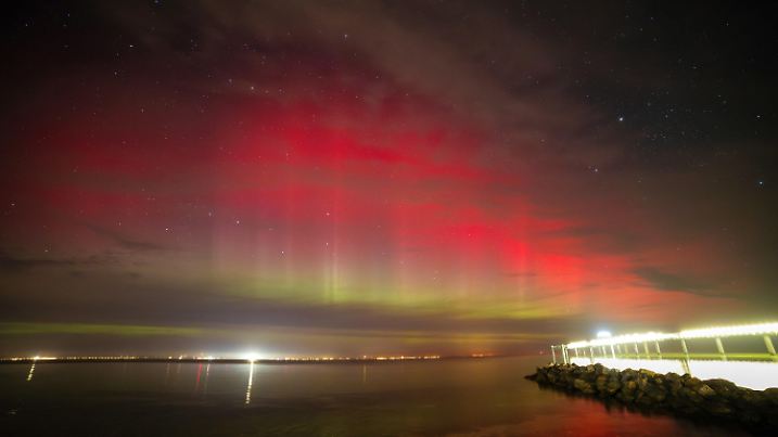 dpatopbilder - 07.10.2024, Schleswig-Holstein, Niendorf: Polarlichter leuchten über der Lübecker Bucht,rechts im Bild ist die Seebrücke Niendorf zu sehen. Nach Angaben des amerikanischen Atmosphärendienstes NOAA gab es in der Nacht einen leichten Sonnensturm. Vorhergesagt waren Polarlichter bereits für Anfang des Wochenendes. Foto: Markus Hibbeler/dpa +++ dpa-Bildfunk +++