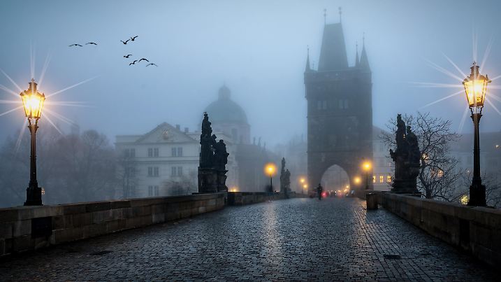 The gothic skyline of Prague, Czech Republic, seen from the famous Charles Bridge on a cold winter morning with fog