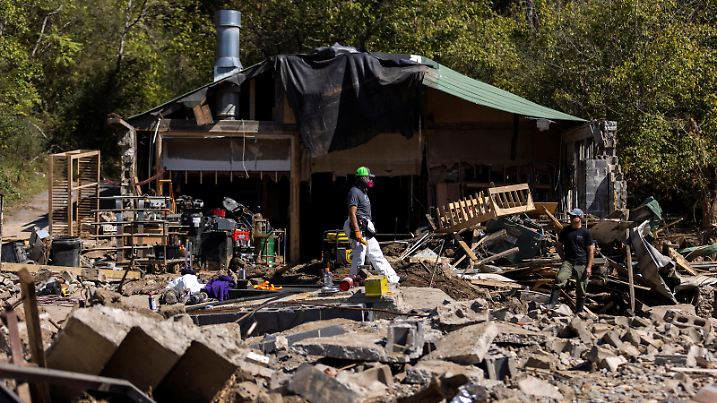 A resident walks through debris following the passing of Hurricane Helene, in Marshall, North Carolina, U.S., October 8, 2024. REUTERS/Eduardo Munoz