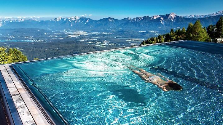 Frau schwimmt im Infinity Pool im Hotel Feuerberg in Kärnten