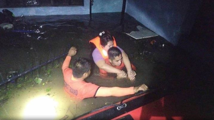 HANDOUT - 23.10.2024, Philippinen, Guinobatan: Das von der philippinischen Küstenwache zur Verfügung gestellten Foto zeigt Rettungskräfte, die während der durch den Tropensturm Trami verursachten Überschwemmungen einen Einwohner in Sicherheit bringen. Foto: Philippine Coast Guard/AP/dpa - ACHTUNG: Nur zur redaktionellen Verwendung im Zusammenhang mit der aktuellen Berichterstattung und nur mit vollständiger Nennung des vorstehenden Credits +++ dpa-Bildfunk +++