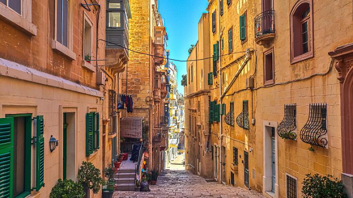 Blick auf eine mediterrane Gasse in einer historischen Altstadt auf Malta