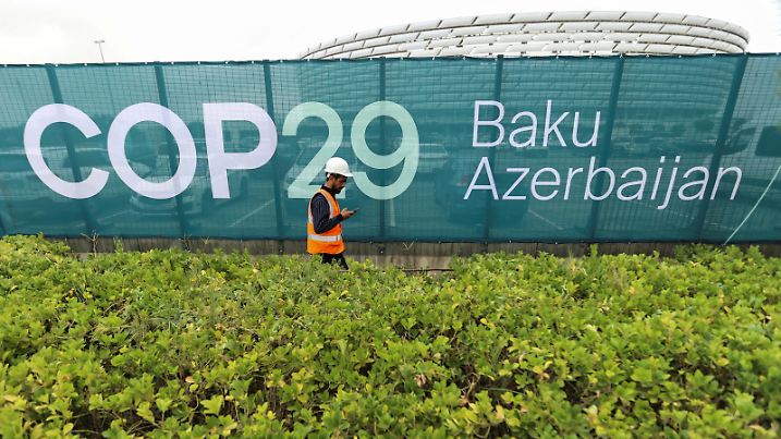 FILE PHOTO: A worker walks along a fence near the Baku Olympic Stadium, the venue of the COP29 United Nations Climate Change Conference, in Baku, Azerbaijan October 18, 2024. REUTERS/Aziz Karimov/File Photo