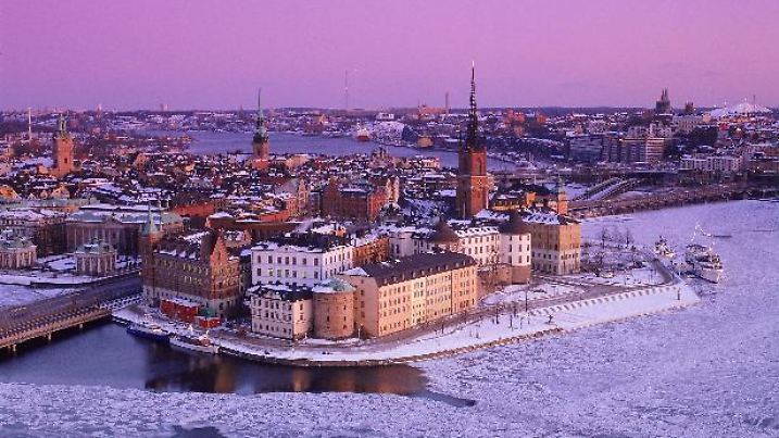 Blick auf Riddarholmen und die Altstadt von Stockholm, die in zartem Winterlicht unter einer Schneedecke liegt. Undatierte Aufnahme. ### Sweden: Stockholm in Winter ## View of Riddarholmen and the old city of Stockholm in a soft winter light and covered with snow. Undated picture. #