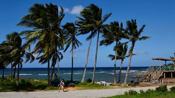 People walk near the beach as Tropical Storm Rafael approaches, in Playa Baracoa, Cuba, November 4, 2024. REUTERS/Norlys Perez