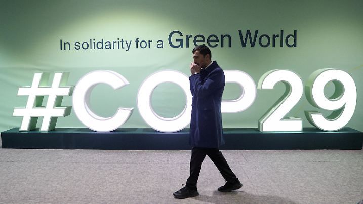 A man walks past an installation with the logo at the venue of the United Nations climate change conference, known as COP29, during a media tour ahead of the summit beginning in Baku, Azerbaijan November 8, 2024. REUTERS/Aziz Karimov