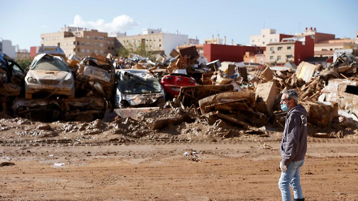 A man stands next to vehicles damaged in deadly floods in Catarroja, Valencia, Spain, November 11, 2024. REUTERS/Eva Manez