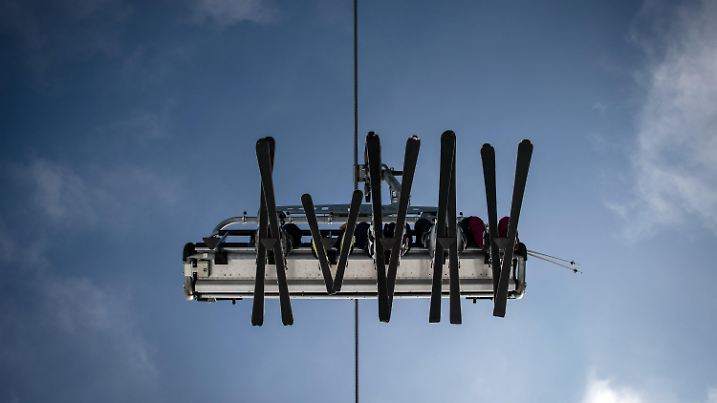 ARCHIV - 07.02.2020, Nordrhein-Westfalen, Winterberg: Skier in einem Lift zeichnen sich vor dem blauen Himmel ab. Noch bevor am Sonntag der erste Schnee im Sauerland fallen könnte, geht in Winterberg der erste Skilift an den Start. Am Poppenberg im Skiliftkarussell können Wintersportler ab Freitag auf einer künstlich beschneiten Piste erste Winterluft schnuppern, kündigte die Wintersport-Arena Sauerland, der Zusammenschluss der Skiliftbetreiber in der Region an.  (zu dpa: «Erster Skihang im Sauerland öffnet am Wochenende») Foto: Bernd Thissen/dpa +++ dpa-Bildfunk +++