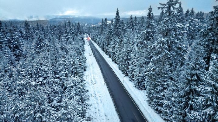 18.11.2024, Sachsen, Tellerhäuser: Ein Auto fährt durch den Winterwald bei Tellerhäuser im Erzgebirge (Luftaufnahme mit Drohne). Mit Schneefall in den Mittelgebirgen und glatten Straßen hat sich in Sachsen der Winter bemerkbar gemacht. Wie der Deutsche Wetterdienst mitteilte, sind am Morgen oberhalb von 600 Metern bis zu fünf Zentimeter Neuschnee gefallen. In der Nacht soll der Vorhersage zufolge im Bergland oberhalb von 700 bis 800 Metern noch einmal Schnee fallen, der später in Regen übergeht. Foto: Jan Woitas/dpa +++ dpa-Bildfunk +++