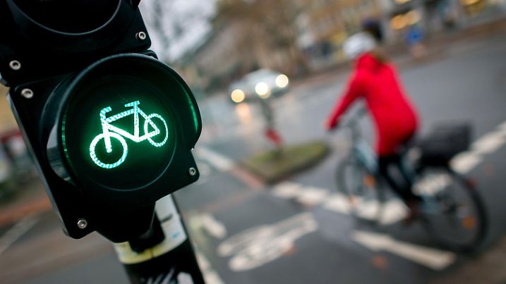 ARCHIV - ILLUSTRATION - Eine Fahrradfahrerin fährt am 18.12.2016 an einer grün leuchtenden Fahrradampel in Hannover (Niedersachsen) vorbei. Sogar Autoclubs fordern inzwischen ein besseres Radwegenetz in Deutschland - zur Not auch zu Lasten des motorisierten Verkehrs. (zu dpa «Eröffnung Nationaler Radverkehrskongress zur Zukunft des Radverkehrs» vom 03.04.2017) Foto: Hauke-Christian Dittrich/dpa +++(c) dpa - Bildfunk+++