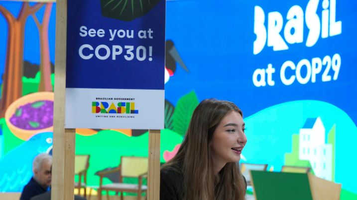 Inara Mammadova walks through the Brazil Pavilion near a sign that reads "see you at COP30!" at the COP29 U.N. Climate Summit, Friday, Nov. 22, 2024, in Baku, Azerbaijan. (AP Photo/Peter Dejong)