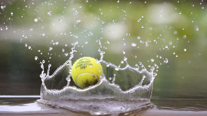 Ein Tennisball am 25.06.2007 im Regenwasser von Wimbledon - Anhaltender Regen führt am Eröffnungstag des Rasenturniers zu einer Reduzierung des Spielprogramms der  All England Championships. Foto: Corinne Dubreuil   +++(c) dpa - Report+++