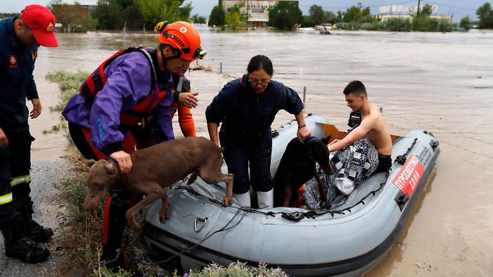 06.09.2023, Griechenland, Larissa: Feuerwehrleute mit einem Schlauchboot evakuieren Menschen und ihre Hunde aus überfluteten Gebäuden. Am 05.09.2023 waren nach einem Unwetter in der Westtürkei nahe der Grenze zu Griechenland und Bulgarien zwei Menschen ums Leben gekommen. Foto: Vaggelis Kousioras/AP/dpa +++ dpa-Bildfunk +++