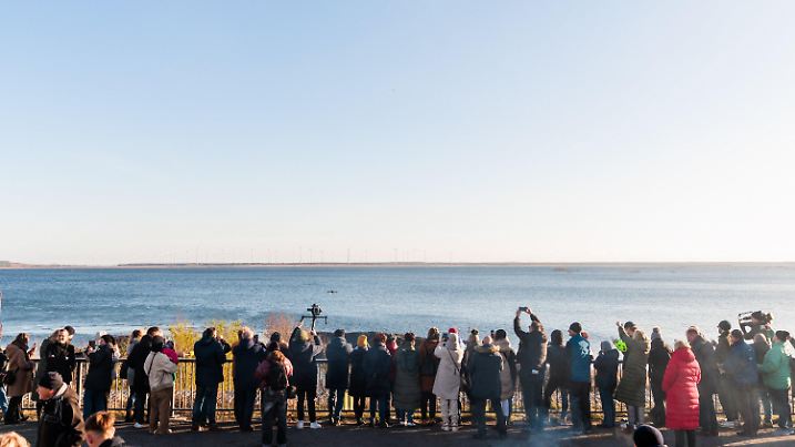 23.12.2024, Brandenburg, Cottbus: Gäste beobachten am Einlassrohr das Erreichen des Zielwasserstandes am Cottbuser Ostsee und die damit verbundene Einstellung der vorläufigen Flutung am Einlaufbauwerk des Cottbuser Ostsees. Foto: Carsten Koall/dpa +++ dpa-Bildfunk +++