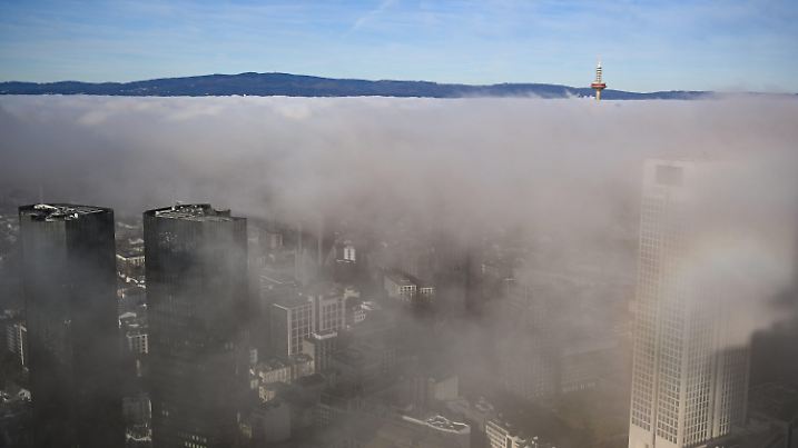 dpatopbilder - 27.12.2024, Hessen, Frankfurt/Main: Eine tiefstehende Wolkenschicht, auch Inversionsschicht genannt, liegt über den Hochhäusern der Bankenstadt. Die Umkehrwetterlage entsteht, wenn die oberen Luftschichten wärmer sind als die unteren. Foto: Arne Dedert/dpa +++ dpa-Bildfunk +++