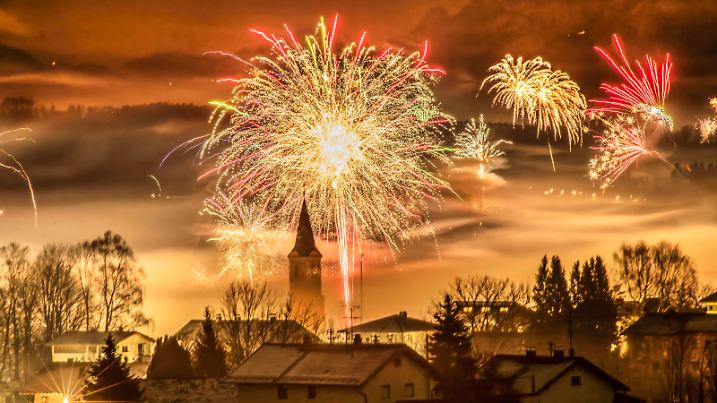 Silvester-Feuerwerk über Glonn, nächtlicher Blick bis zu den Alpen, Glonn in Oberbayern, 1. Januar 2025 Deutschland, Glonn, Landkreis Ebersberg, 1. Januar 2025, Silvester-Feuerwerk kurz nach Mitternacht, ein dichter Feinstaub-Nebel liegt über dem Ort, der Kirchturm der katholischen Pfarrkirche St. Johannes ragt aus dem Feuerwerksnebel, Blick bis zu den Alpen, die sich am Horizont schemenhaft abzeichnen, Inversionswetterlage, Oberbayern, Glonn hat ca. 5.300 Einwohner, hohe Feinstaubbelastung, Umwelt, Bayern