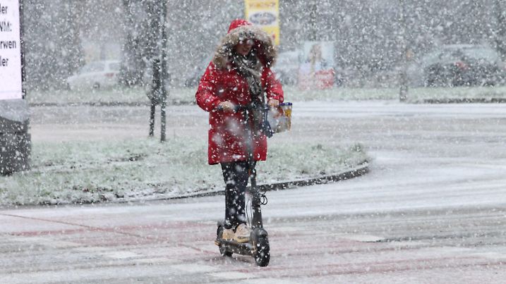 Wintereinbruch in Hamburg. Am Freitagvormittag gab es phasenweise heftigen Schneefall in der Hansestadt. Eine Frau passiert auf einem E-Roller die Kreuzung Wiesendamm/Saarlandstraße. Barmbek Hamburg *** The onset of winter in Hamburg On Friday morning there were periods of heavy snowfall in the Hanseatic city A woman on an e-scooter passes the Wiesendamm Saarlandstraße Barmbek intersection Hamburg