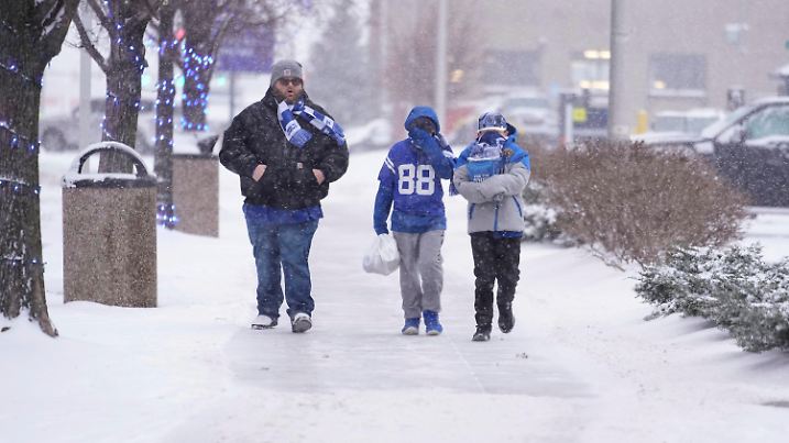 05.01.2025, USA, Indianapolis: Fans der Indianapolis Colts laufen nach einem NFL-Footballspiel zwischen den Colts und den Jacksonville Jaguars durch den fallenden Schnee. Foto: Michael Conroy/AP/dpa +++ dpa-Bildfunk +++