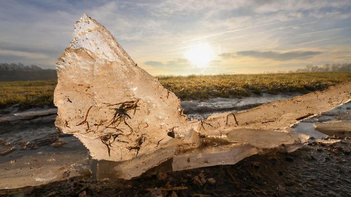 06.01.2025, Baden-Württemberg, Riedlingen: Eisschollen ragen am Morgen kurz nach Sonnenaufgang aus einer gefrorenen Pfütze Foto: Thomas Warnack/dpa +++ dpa-Bildfunk +++
