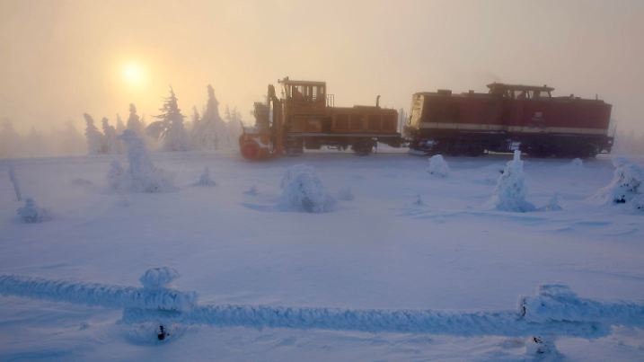 12.01.2025, Sachsen-Anhalt, Schierke: Mit einer Schneeschleuder räumen Mitarbeiter der Harzer Schmalspurbahn GmbH auf dem Brocken Schnee aus den Gleisen. Foto: Matthias Bein/dpa +++ dpa-Bildfunk +++