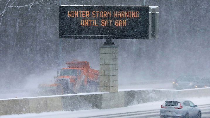 22.12.2022, USA, Madison: Ein Schneeräumfahrzeug räumt die Straße, während ein Verkehrsschild die Fahrer vor den Bedingungen auf dem State Highway 14/18 warnt. Foto: John Hart/Wisconsin State Journal/AP/dpa +++ dpa-Bildfunk +++